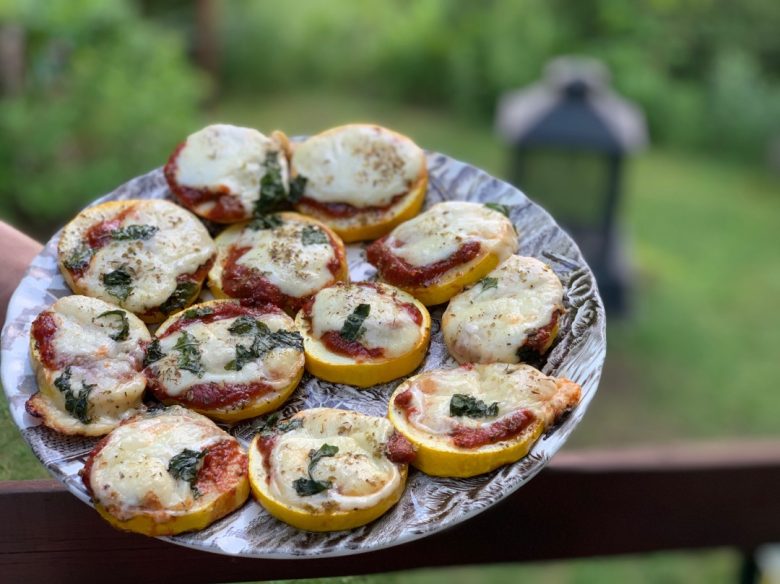 Mini pizzas de courgettes grillées sur le BBQ, garnies de sauce tomate maison, fromage fondu, origan et basilic.