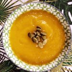 Bol de potage à la courge musquée rôti, servi avec graines de citrouille, yogourt et pain grillé à l’ail.