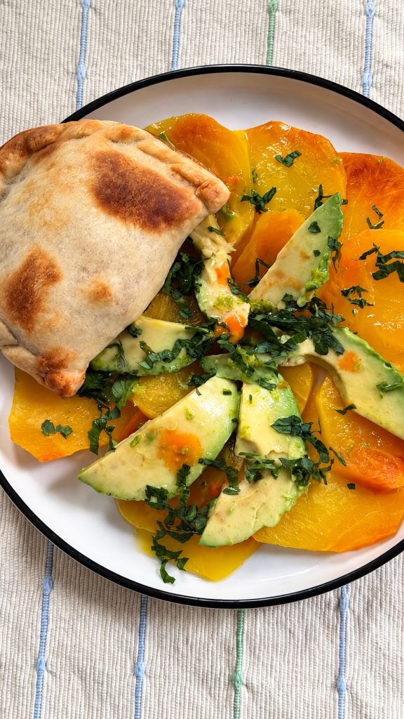 Salade de betteraves jaunes et avocat servie avec un empanada au poulet